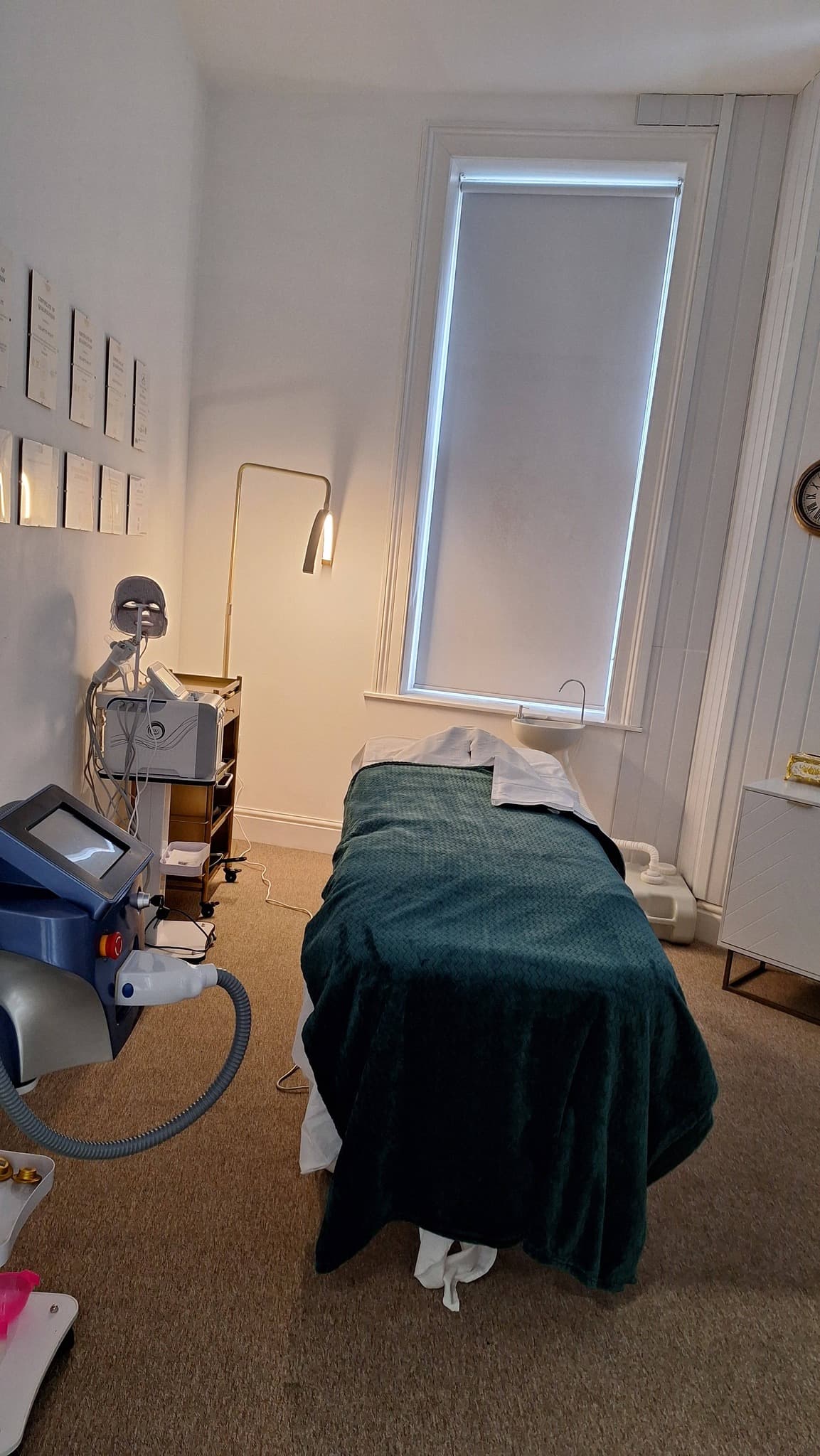 Laser treatment room with treatment bed, gold standing arc light and a Diode laser machine.